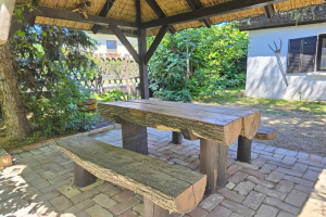 Közelről a fedett pergola faasztala és padjai